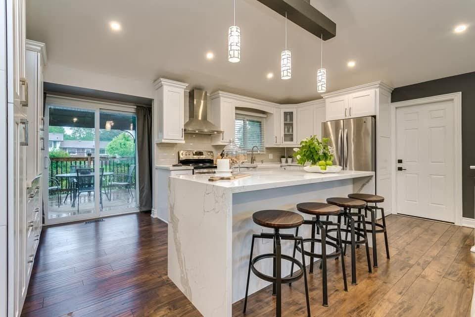 Renovated kitchen with waterfall marble island and pendant lighting